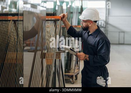 Confident look, quality control. Warehouse worker in an industrial environment of a factory or storage area. Stock Photo