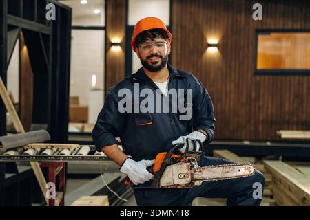 Cheerful facial expression. Portrait of a male carpenter posing in a woodworking workshop. Stock Photo