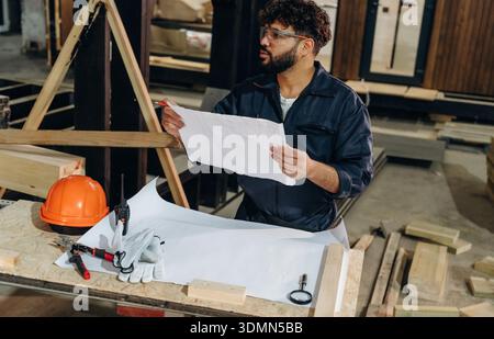 In a professional workshop. Male carpenter working with wooden materials. Stock Photo