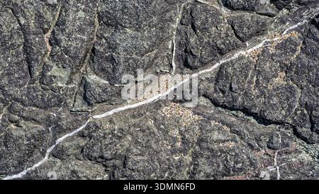 Abstract marble veining patterns and sand grains on a natural granite surface Stock Photo