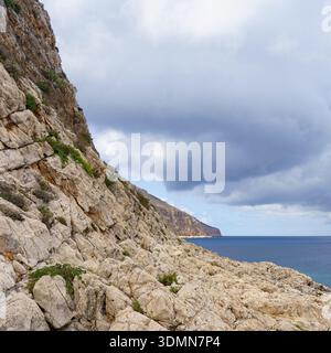 A dramatic panoramic view of the rugged, pale limestone cliff area between Cala Nucidda and Cala Stella Marina on Levanzo Island, capturing the raw ge Stock Photo