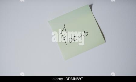 Sticky note with handwritten focus text on white background minimal concept Stock Photo