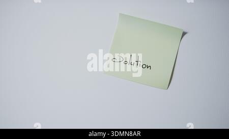 "Solution" Handwritten on Tilted Green Sticky Note — Problem Solving and Business Concept Stock Photo