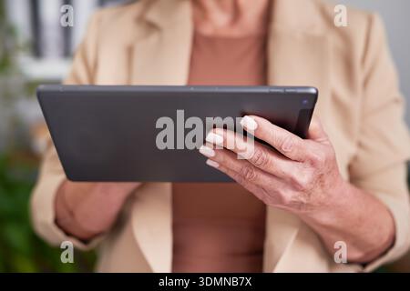 Business Professional Using Tablet Device in Modern Office Setting for Work, Communication, and Productivity Stock Photo