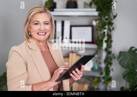 Senior Businesswoman With Tablet in Office, Smiling Professional Portrait Stock Photo