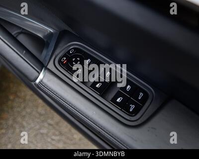 Close-up of car door window controls and mirror adjustment buttons Stock Photo
