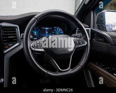 Close-up of modern car steering wheel and dashboard display in rain Stock Photo