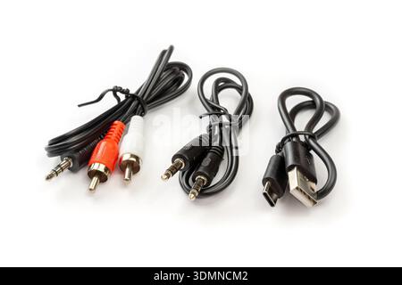 Three short connection cables isolated on white background, product photo closeup: 3.5mm audio aux jack to RCA red white plugs, 3.5mm male to male ste Stock Photo