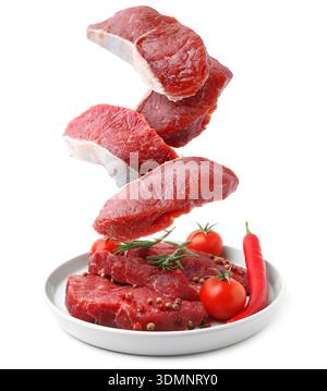 Fresh beef steaks falling on white background Stock Photo