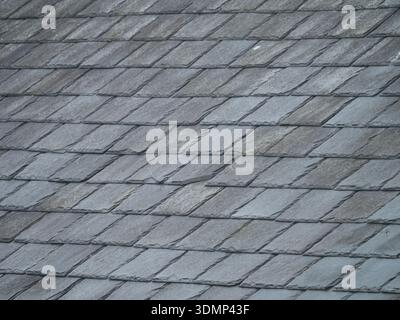Weathered slate roof tile texture background with natural grey stone pattern and copy space. Stock Photo