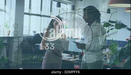 Discussing standing duo pointing at tablet and smartphone in loft woman sleeveless man buttonup HUD Stock Photo
