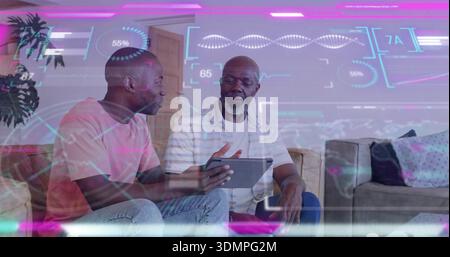 Talking son in pink T-shirt with tablet, guiding father in stripes on beige sofa, showing holograms Stock Photo