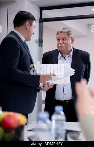 Professional conversation between two colleagues in a modern office environment Stock Photo