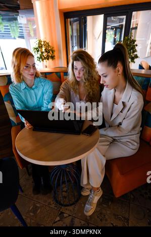 Businesswomen collaborating on a project in a modern cafe environment while discussing ideas and strategies for their work Stock Photo