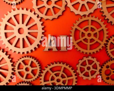 The letters AI Artificial Intelligence surrounded by various wooden gear wheels on an orange background. Stock Photo