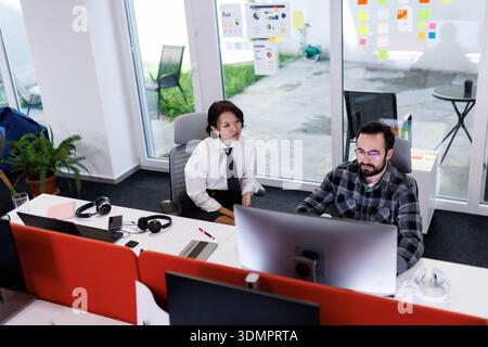 Business meeting between colleagues in a modern office space while discussing project details in the afternoon light Stock Photo