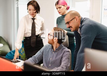 Business meeting featuring diverse professionals collaborating in a modern office space during a weekday afternoon Stock Photo