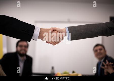 Professional handshake between colleagues in a business meeting setting Stock Photo