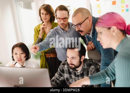 Business team collaborates on project in modern office space while analyzing data and brainstorming together Stock Photo