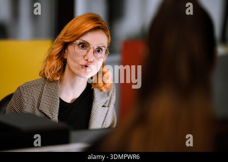 Engaging conversation between two professionals in a modern office setting during the day Stock Photo