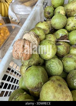 The walnuts among the fresh walnuts in green husk for sale at the market in Lanzhou, China Stock Photo