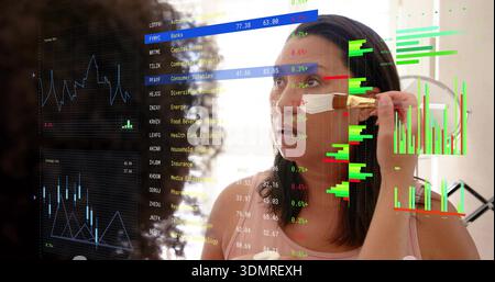 Applying makeup, woman in pink sleeveless top holding brush at vanity mirror, market overlays Stock Photo
