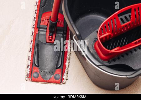 Floor cleaning mop and bucket closeup. Household washing equipment and domestic cleaning supplies concept indoors at home. Stock Photo