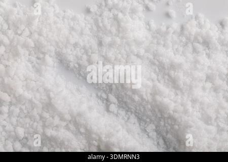 "A close-up view from above of stevia crystal grains shows an irregular, uneven texture where light reflects off the multifaceted grains." Stock Photo
