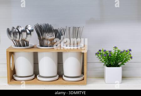 Kitchen cutlery organizer with forks, spoons and chopsticks on countertop Stock Photo