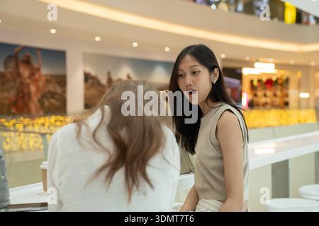 Young asian woman surprising reacting during conversation with friend Stock Photo