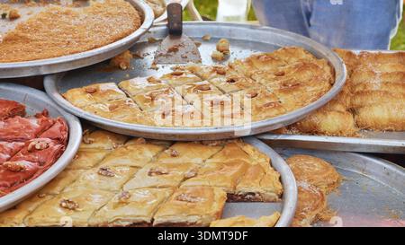Assortment of sweet baklava and kadayif pastries at a street food market stall Stock Photo