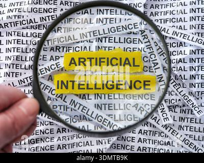 A person with a magnifying glass in his hand magnifying the words Artificial Intelligence on a crumpled newspaper background. Close up. Stock Photo