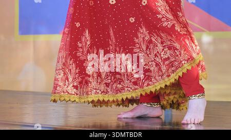 Indian bride wearing traditional red lehenga with intricate golden embroidery at a ceremony Stock Photo