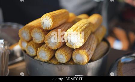 Boiled yellow corn cobs piled in a container, a popular street food snack in India Stock Photo