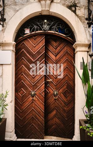 Ornate wooden arched door in historic stone building Stock Photo