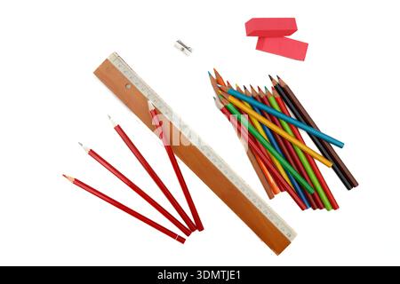 The image presents a close-up view of an aged vintage slide rule, an eraser, several sharpened pencils, and a pencil sharpener. These objects are situ Stock Photo