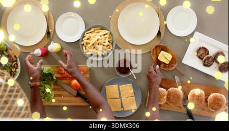 Chopping father and son using cutting board, arranging buns at dining table, checked shirt, watch Stock Photo