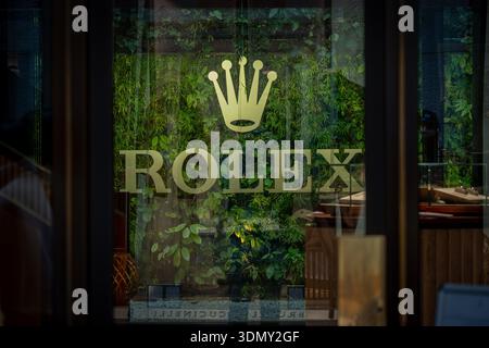 Milan, Italy - 2026, 3 Feb: Elegant Rolex storefront with gold logo, lush green wall, and modern design, capturing luxury and FW25 fashion sophisticat Stock Photo