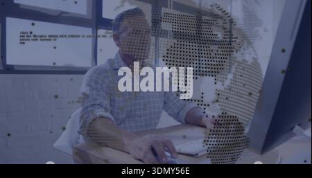 Working mature man wearing light checkered shirt using mouse at office desk, with monitor overlay Stock Photo