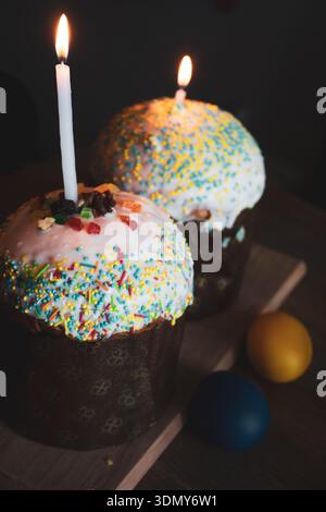 Easter cake with candles and festive decor. Easter still life. Orthodox Eater celebration. Colourful Easter eggs with sweet glazing cakes Stock Photo