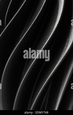 A close-up view of smooth, flowing plastic waves creating an abstract background. The curves and textures of the material provide a sense of movement Stock Photo