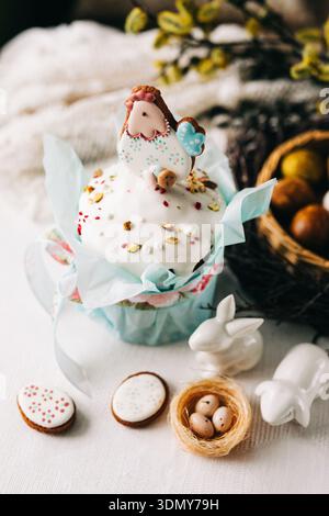 Delight in a festive Easter cake adorned with an adorable icing hen, colorful decorations, and surrounded by spring-themed accents like eggs and bunni Stock Photo