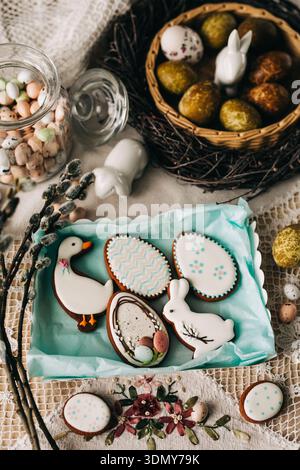 A delightful arrangement of decorative Easter cookies featuring bunnies, eggs and a duck, surrounded by pastel candies and spring decorations, perfect Stock Photo