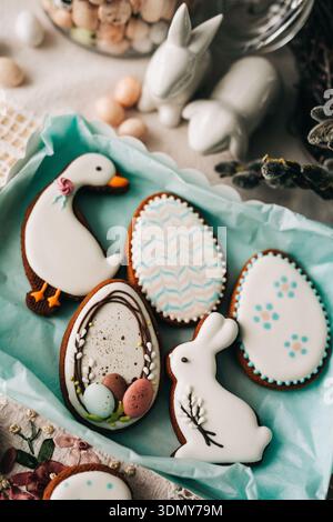 Festive Easter cookies shaped like eggs, bunnies and ducks are beautifully iced and surrounded by springtime motifs. Ideal for holiday celebrations an Stock Photo