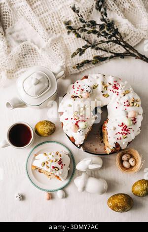 A beautifully decorated Easter cake with white icing, sprinkled with pistachios and candy eggs, perfect for springtime celebrations and holiday gather Stock Photo
