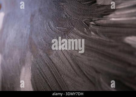 Close-up of a textured gray canvas, showcasing abstract brushstrokes. The image highlights the intricate details of paint texture and canvas weave, pe Stock Photo