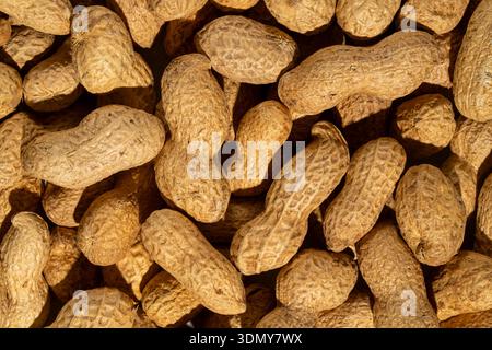 A detailed close-up image of peanuts in their shell, showcasing the textured surface and natural coloring of these whole nuts. Ideal for food-related Stock Photo