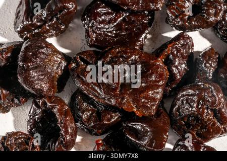 Close-up of dried prunes, showcasing their rich texture and dark color. Ideal for culinary presentations, packaging, or illustrating articles on dried Stock Photo