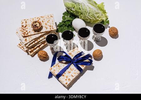 A beautifully arranged Passover scene showcasing traditional elements including matzah, wine glasses, nuts, and a decorative blue ribbon, symbolizing Stock Photo