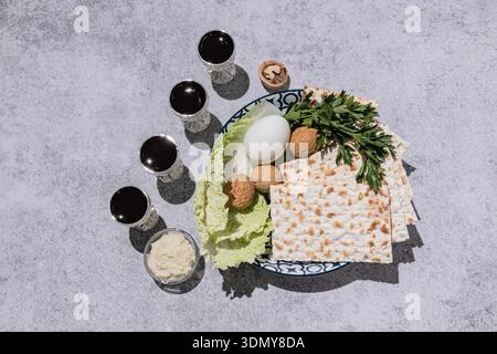 Celebrate Passover with a traditional seder plate featuring matzah, walnuts, parsley, cabbage, egg, and wine. Perfect for honoring Jewish culture and Stock Photo